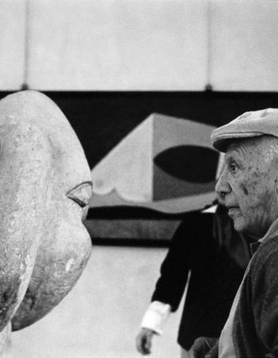 5. Picasso observa en una de las salas del Museo de Antibes su pieza Cabeza de mujer con moño, de 1931<br/>Gelatina de plata virada al selenio / Selenium toned gelatin silver print