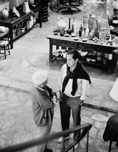 Picasso y Luis Miguel Dominguín conversan en la planta baja de Madoura<br/>Gelatina de plata virada al selenio / Selenium toned gelatin silver print