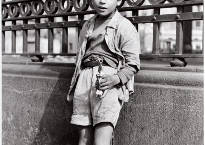 Niño con pistola. Barcelona, 1959<br/>Gelatina de plata sobre papel baritado positivada por el autor con anotaciones y sello 
de tinta en reverso